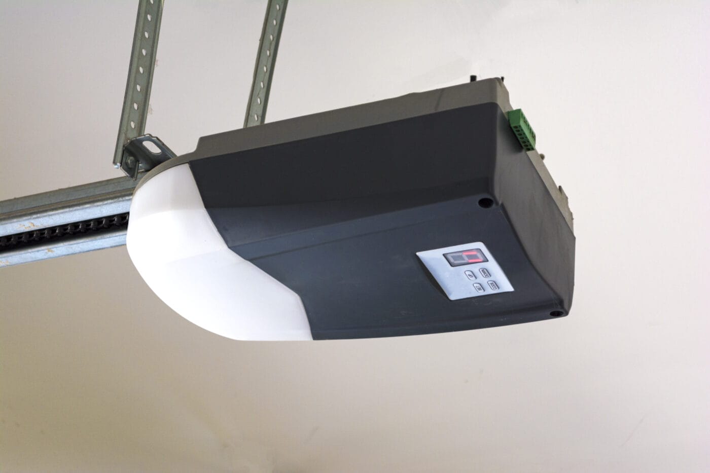 Close-up of an automatic garage door opener motor on the ceiling.